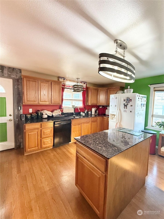 kitchen featuring pendant lighting, sink, dishwasher, white fridge with ice dispenser, and light wood-type flooring