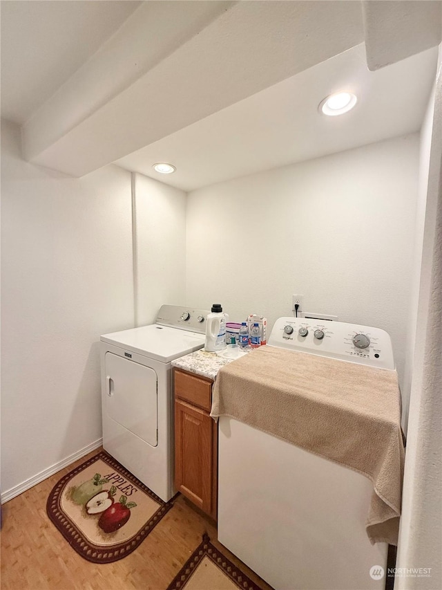 laundry room featuring cabinets, independent washer and dryer, and light hardwood / wood-style floors