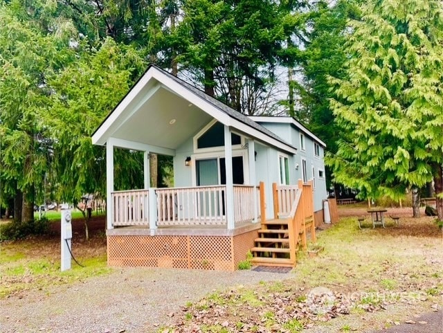 back of property featuring covered porch