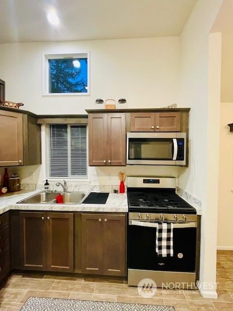 kitchen featuring appliances with stainless steel finishes, sink, and dark brown cabinets