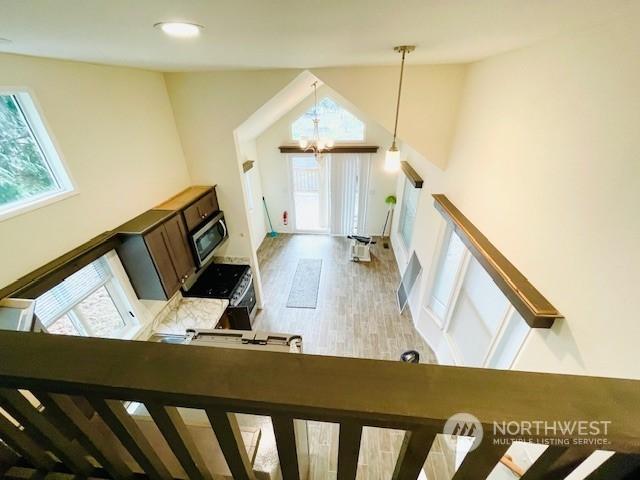 living room featuring an inviting chandelier, hardwood / wood-style floors, and high vaulted ceiling