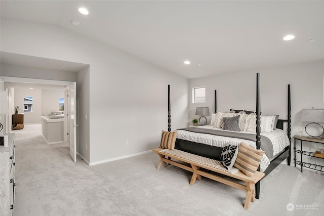 bedroom with light colored carpet and lofted ceiling