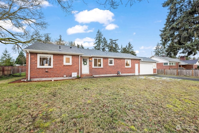 rear view of house featuring a garage and a yard