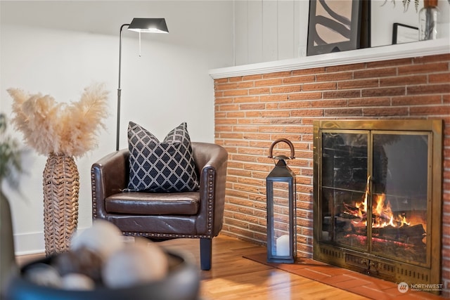 sitting room with hardwood / wood-style flooring and a fireplace