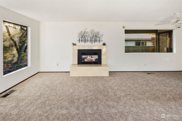 unfurnished living room featuring carpet flooring, a textured ceiling, and ceiling fan