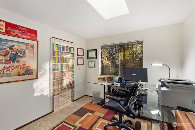 carpeted office space featuring a skylight