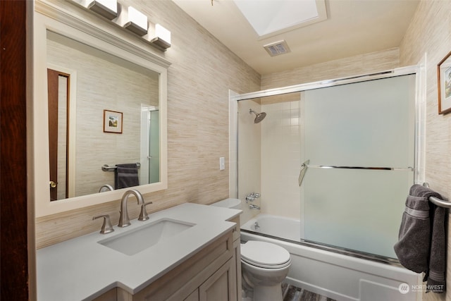 full bathroom featuring vanity, toilet, and combined bath / shower with glass door