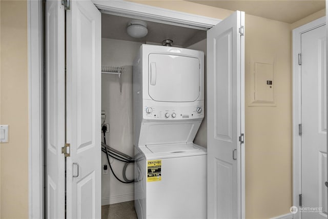 laundry area with stacked washer and clothes dryer and electric panel