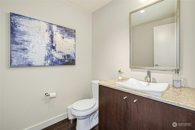 bathroom featuring vanity, toilet, and hardwood / wood-style floors