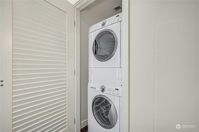 washroom featuring stacked washer / dryer