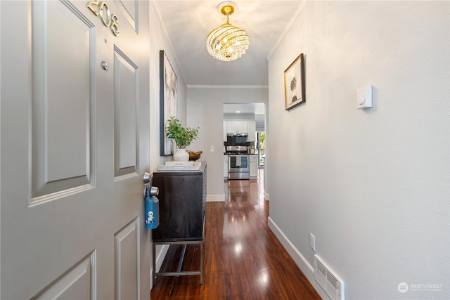 hallway featuring an inviting chandelier, ornamental molding, and dark hardwood / wood-style floors