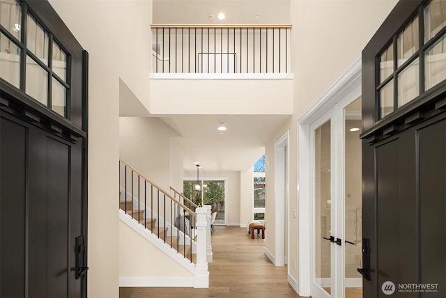 entrance foyer featuring a towering ceiling and light hardwood / wood-style floors