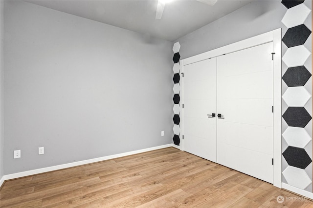 unfurnished bedroom with light hardwood / wood-style flooring, a closet, and ceiling fan