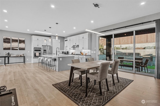 dining room with sink and light hardwood / wood-style flooring