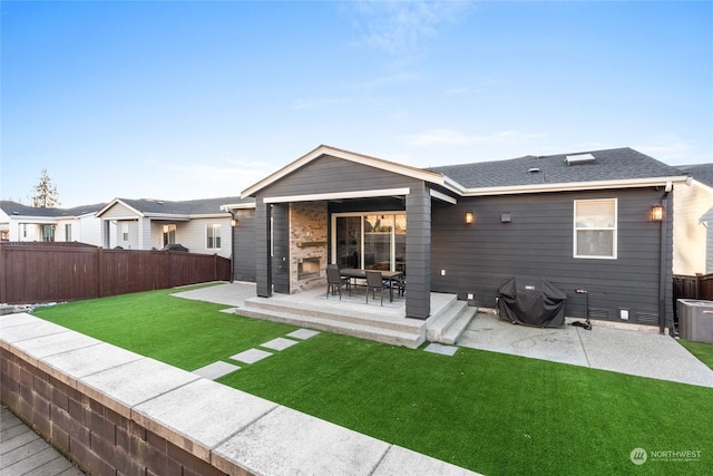 rear view of house featuring central AC, a lawn, and a patio area