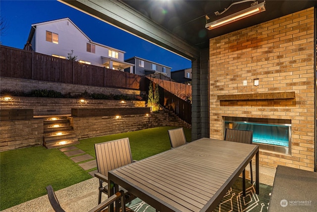 patio at night featuring a yard