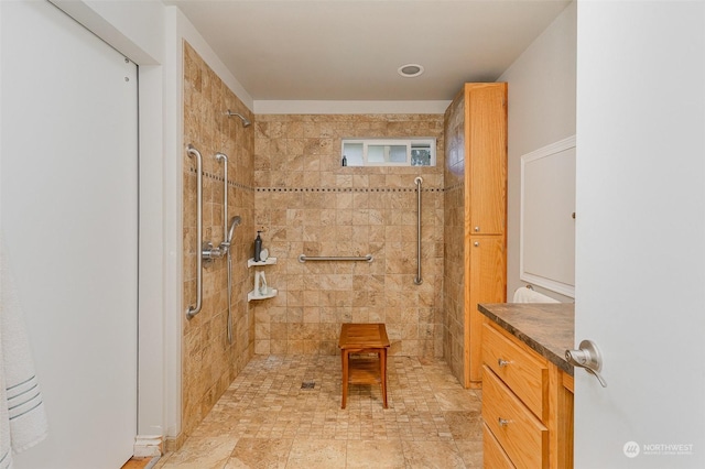 bathroom featuring tiled shower and vanity