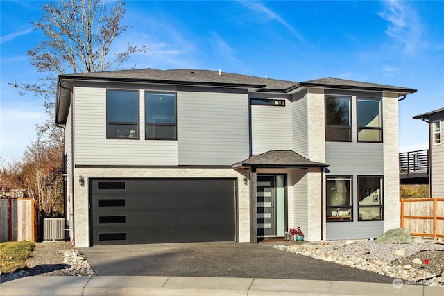 view of front facade with a garage and central AC