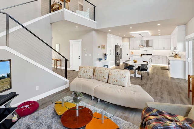 living room with dark hardwood / wood-style flooring, sink, and a towering ceiling