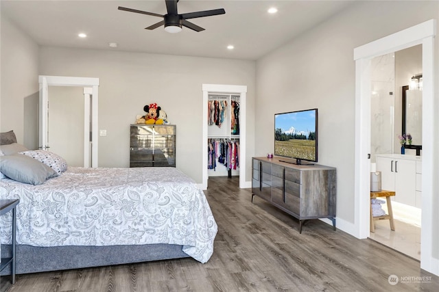 bedroom with ceiling fan, hardwood / wood-style floors, a closet, and a walk in closet