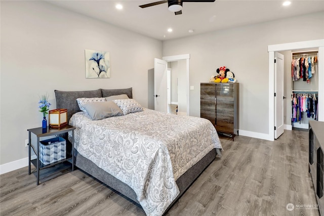 bedroom featuring a walk in closet, wood-type flooring, a closet, and ceiling fan