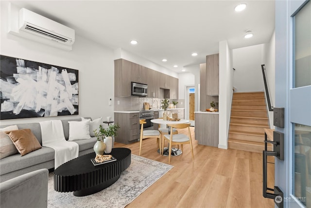 living room featuring a wall mounted AC and light hardwood / wood-style floors