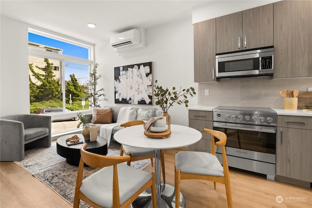 kitchen featuring appliances with stainless steel finishes, a healthy amount of sunlight, an AC wall unit, and backsplash