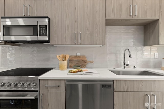 kitchen with stainless steel appliances, sink, light brown cabinets, and backsplash