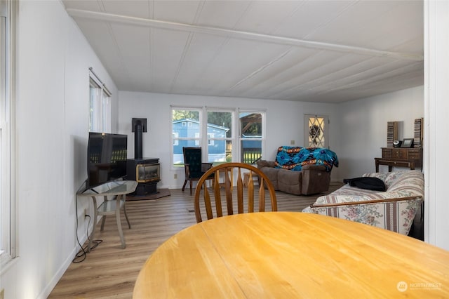 dining space with hardwood / wood-style flooring and a wood stove