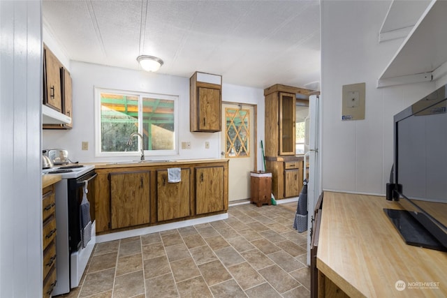 kitchen with white electric stove, a healthy amount of sunlight, sink, and a textured ceiling