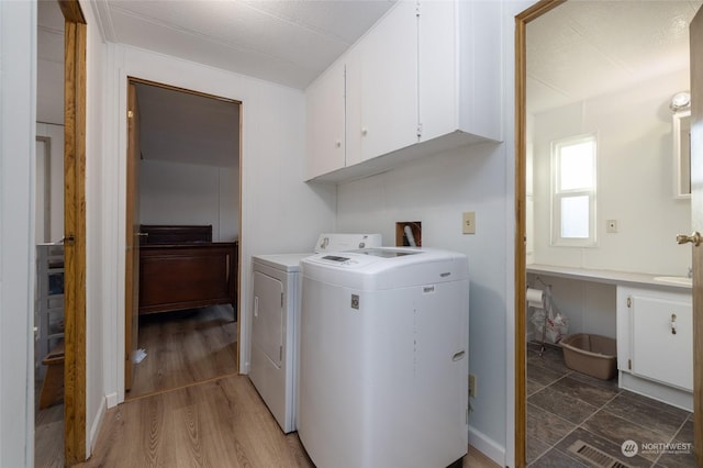 laundry room featuring cabinets, dark hardwood / wood-style floors, and washing machine and dryer