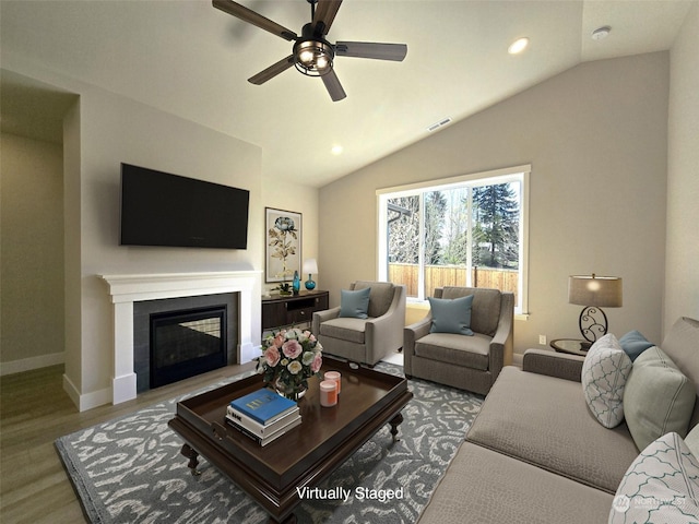 living room with vaulted ceiling, ceiling fan, and light hardwood / wood-style floors