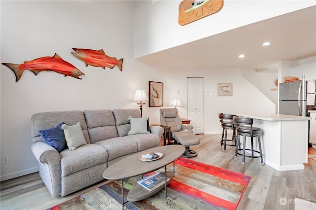 living room featuring bar and light hardwood / wood-style floors