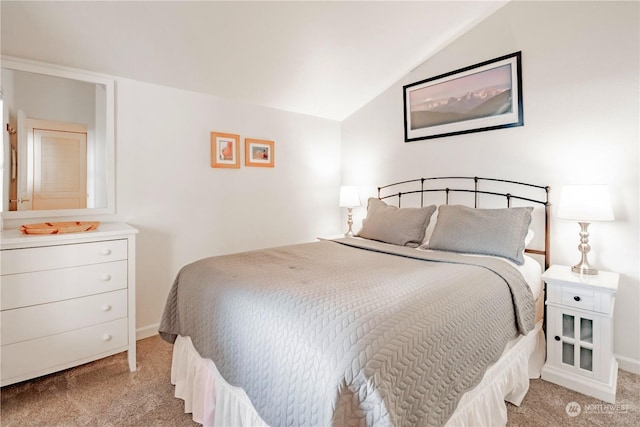 carpeted bedroom with lofted ceiling