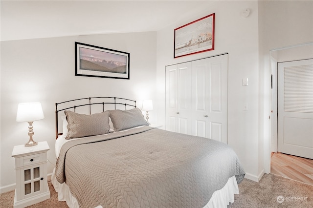 carpeted bedroom with lofted ceiling and a closet