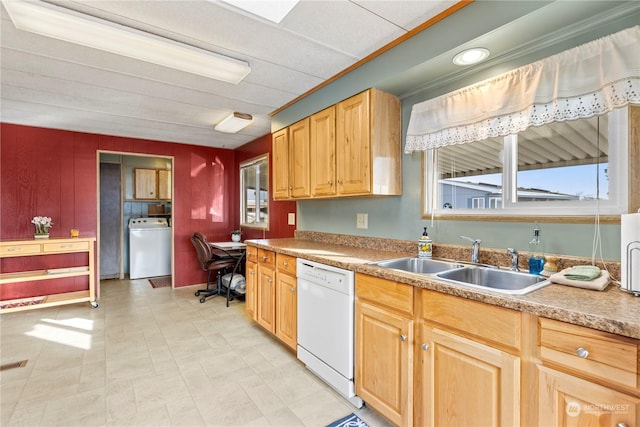 kitchen featuring white dishwasher, washer / dryer, and sink