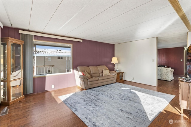 living room featuring dark hardwood / wood-style flooring and wood walls