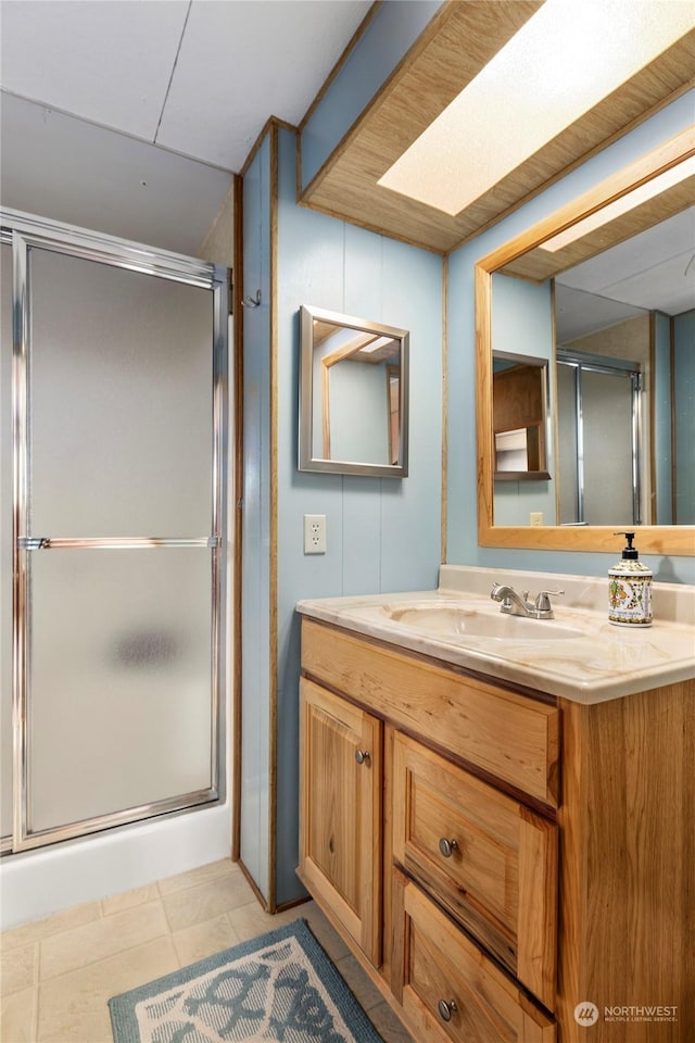 bathroom featuring walk in shower, vanity, and tile patterned flooring