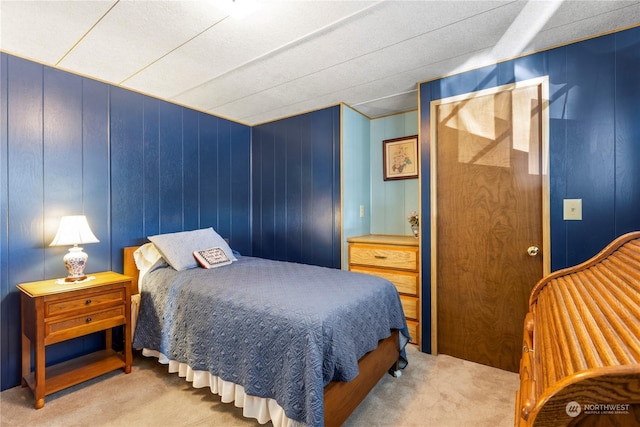 carpeted bedroom featuring wooden walls