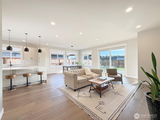 living room featuring sink and light hardwood / wood-style floors