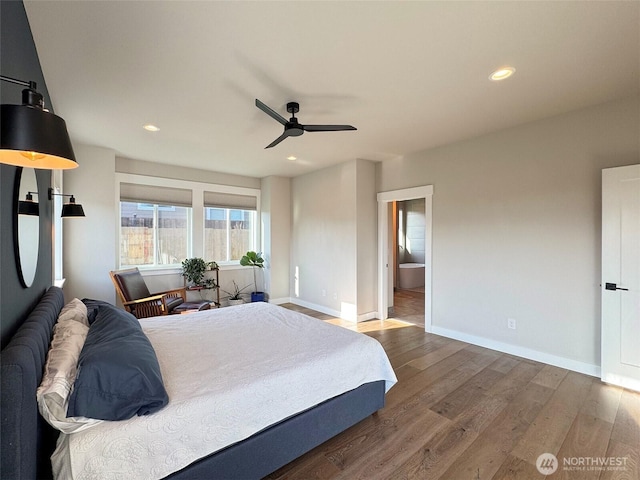 bedroom featuring ceiling fan, ensuite bath, and dark hardwood / wood-style flooring