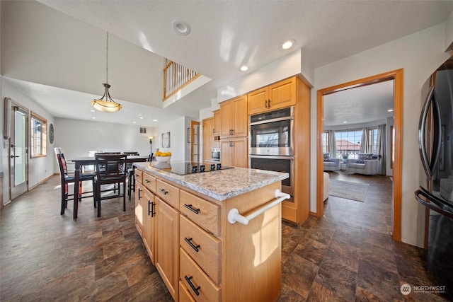 kitchen with a kitchen island, light brown cabinetry, hanging light fixtures, light stone counters, and black appliances