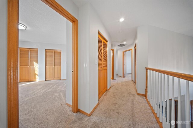 hall featuring light colored carpet