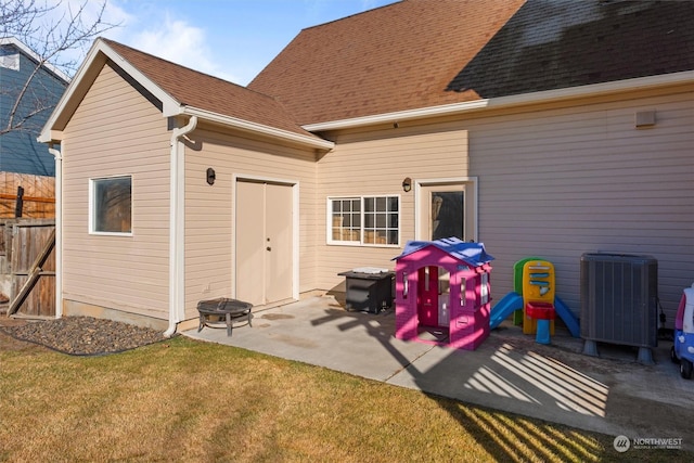 back of property featuring central AC unit, a patio area, and a lawn