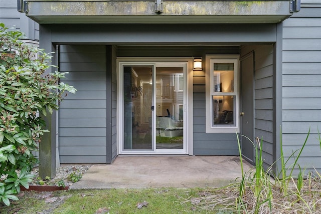 view of exterior entry with a patio area