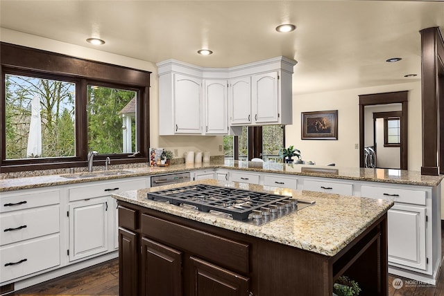 kitchen featuring sink, appliances with stainless steel finishes, dark hardwood / wood-style floors, white cabinets, and a kitchen island