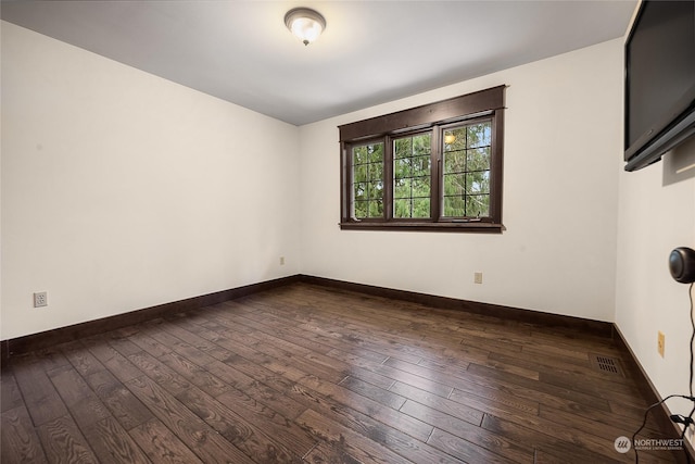 empty room with dark hardwood / wood-style flooring