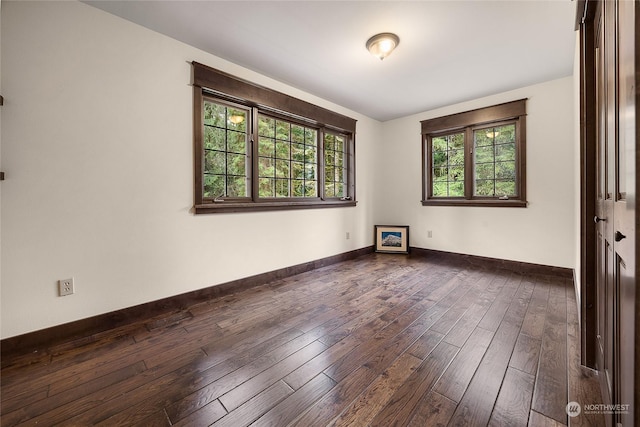 unfurnished room with plenty of natural light and dark hardwood / wood-style flooring