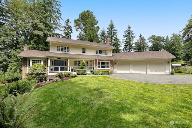 view of front property with a porch, a garage, and a front lawn