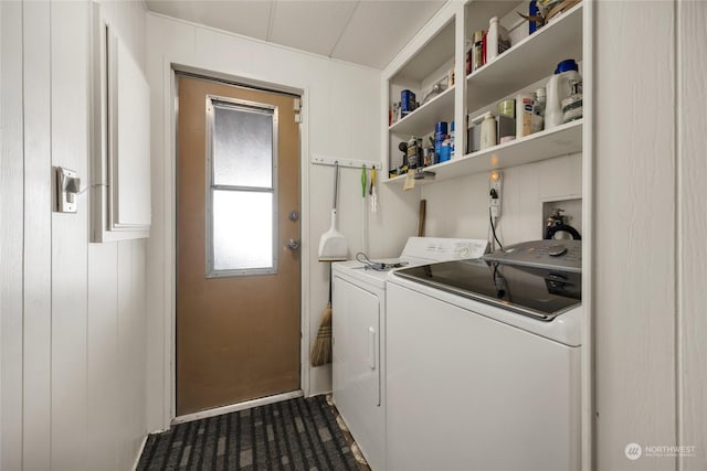 clothes washing area featuring wood walls and washing machine and clothes dryer